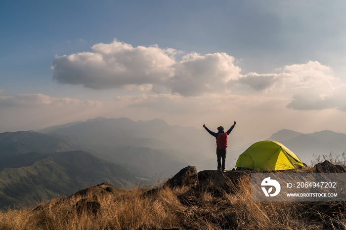 Young man traveler with backpack camping on mountain, Adventure travel lifestyle concept