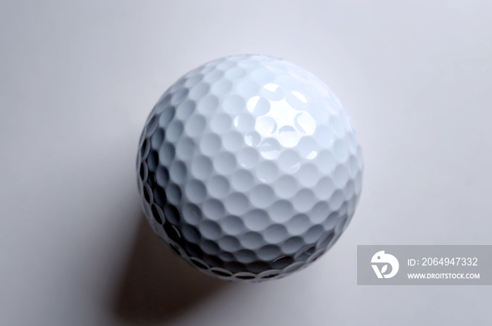 Single white golf ball from above. American golf ball with special notches, designed to be used in t