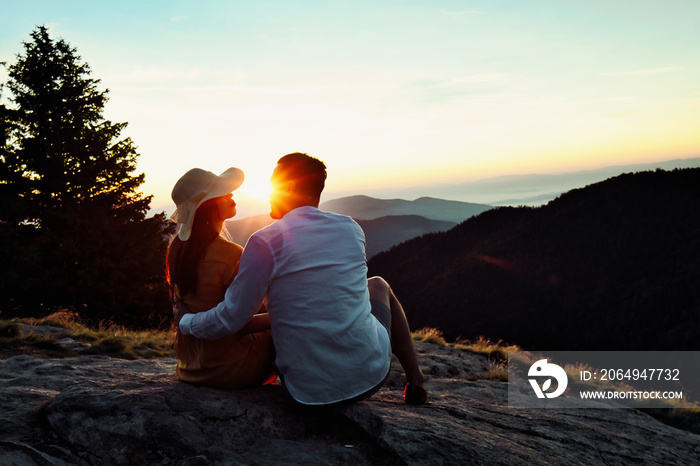 Happy couple hugging on the top of a mountain.