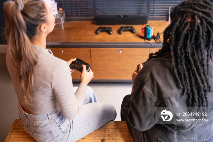 Female friends playing in video games at pub