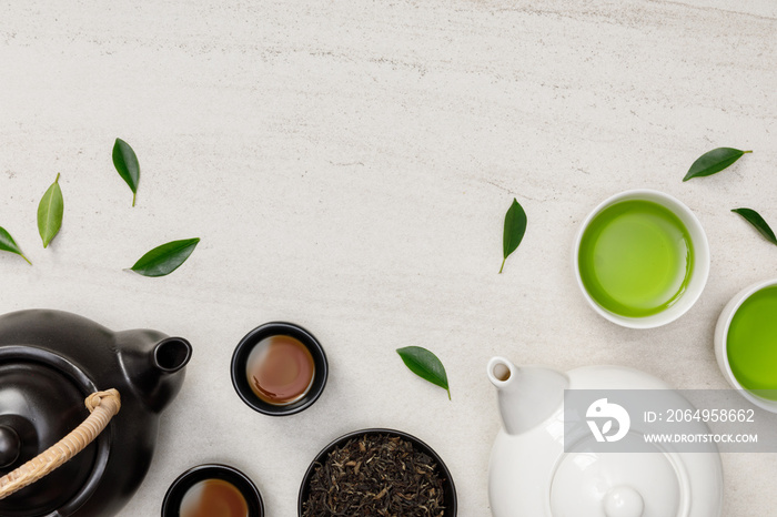 一杯热茶，配茶壶、绿茶叶和干香草，白色石桌上的俯视图是空的