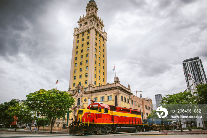 Train crosses Biscayne Boulevard in front of Freedom Tower to get to the port of Miami