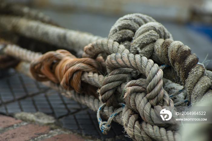 Closeup of old and thick mooring rope in a port