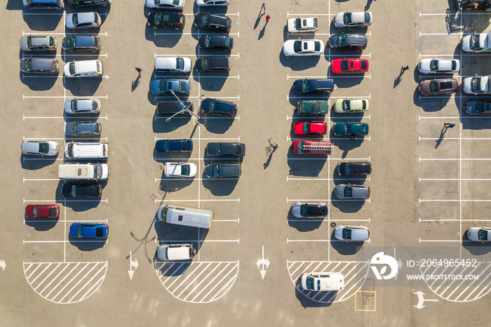 Aerial view of many colorful cars parked on parking lot with lines and markings for parking places a