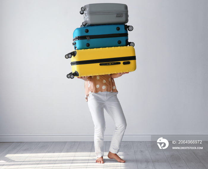 Young woman with suitcases in room. Luggage overweight concept