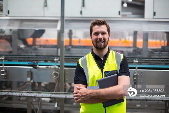 Portrait of smiling factory worker with a tablet