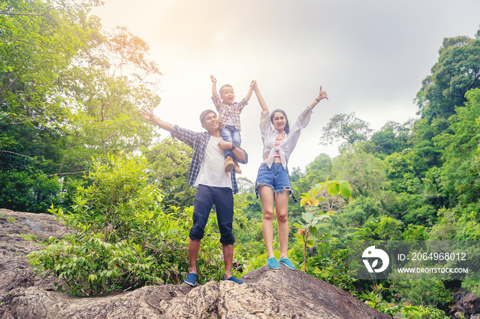 Happiness family standing travel together and open arms celebrate their vacation with big forest