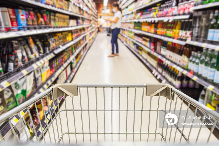 Shopping cart in super market with consumer in protective mask in blur background coronavirus concep