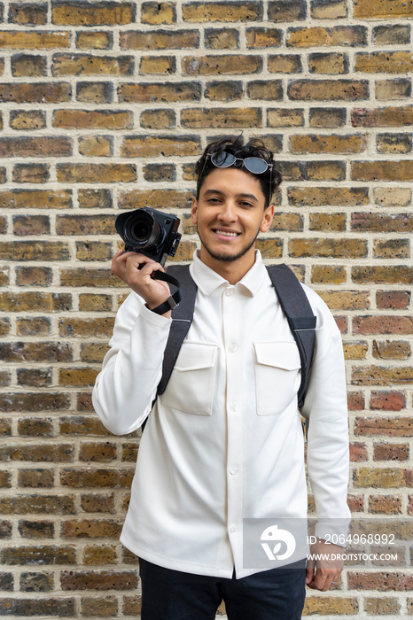 Portrait of young man holding camera