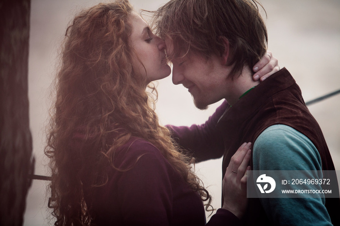 Young woman kissing mans forehead