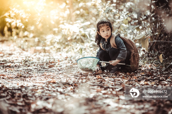 夏令营。一个可爱的小女孩用她的漏网捕捉蝴蝶和虫子。亚洲人和美国人
