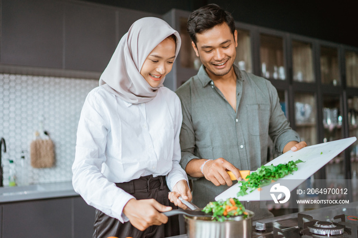 beautiful young muslim couple cooking together
