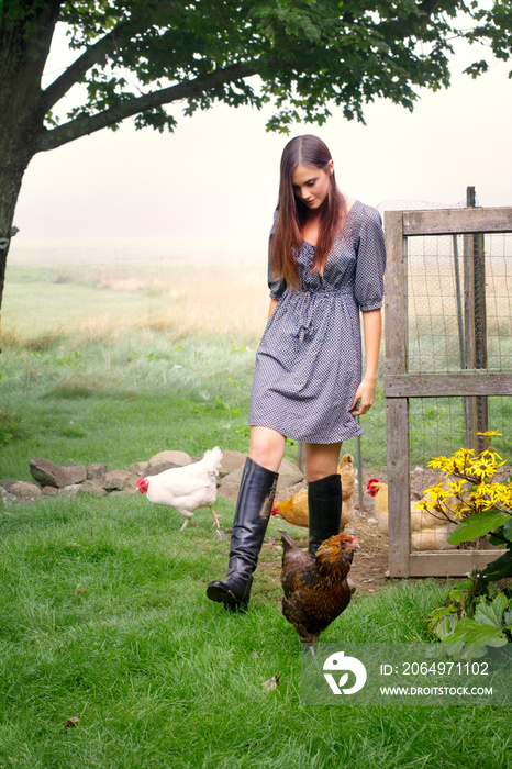 Young woman on farm with chickens