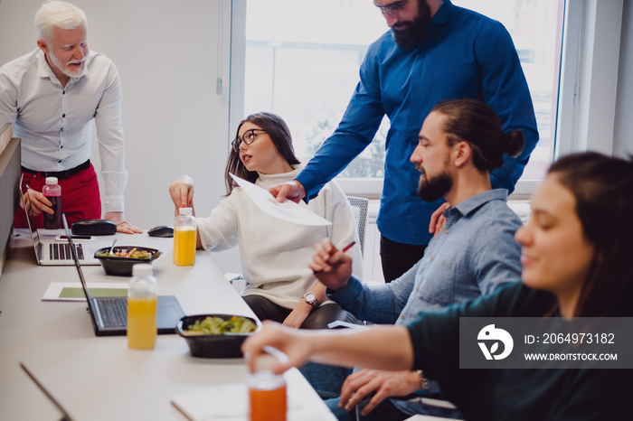 Coworkers discussing and having lunch in the office