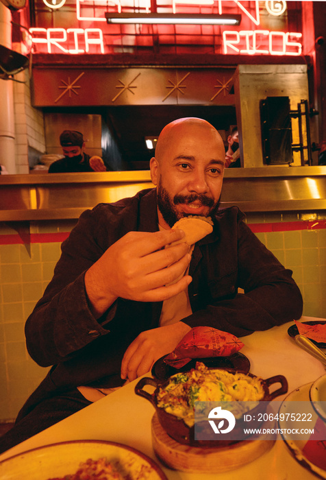 Smiling man having tacos in Mexican restaurant