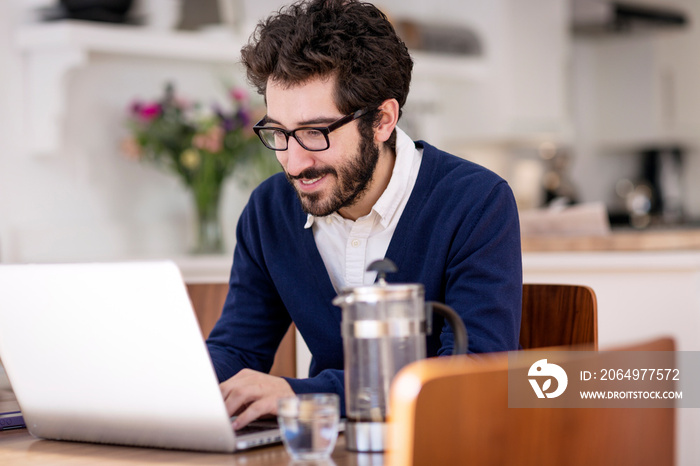 Mid-adult man surfing net in living room