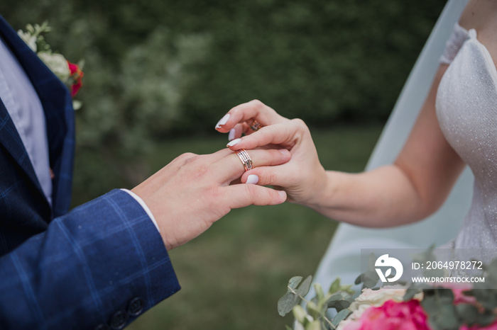 the bridegroom puts a ring on the bride’s finger