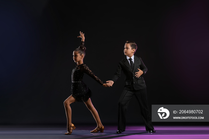 Cute little children dancing against dark background