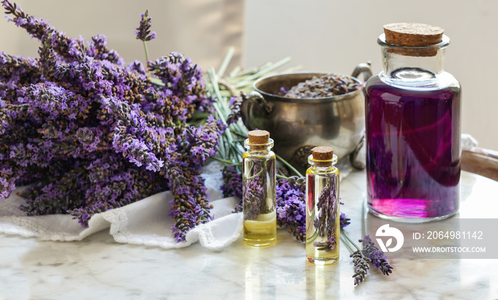 lavender oil bottles,  natural herb cosmetic consept with lavender flowers flatlay on stone backgrou