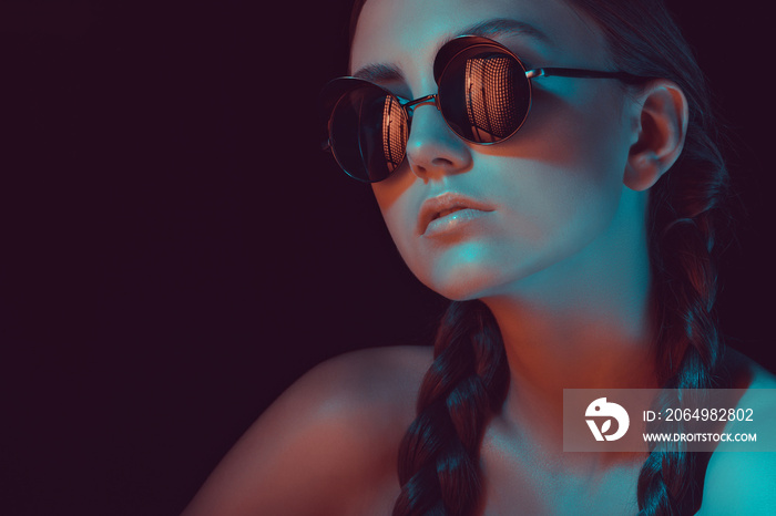 portrait of young stylish woman with braids in fashionable sunglasses
