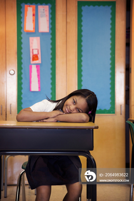 Portrait of schoolgirl leaning against desk