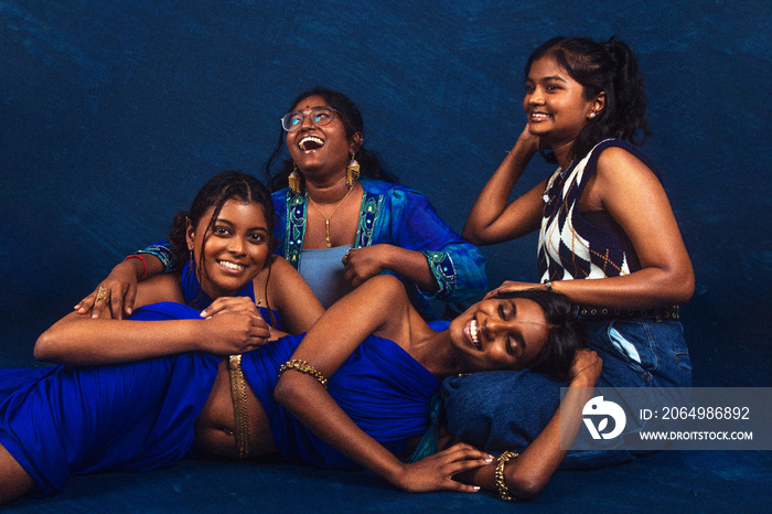 group portraits of dark skinned Indian women from Malaysia against a dark blue background