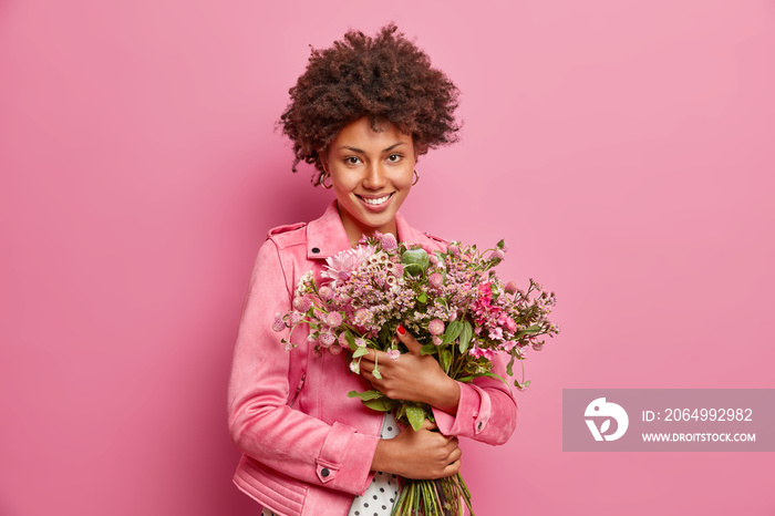 可爱的卷发非裔美国女子拥抱男友送的一大束鲜花