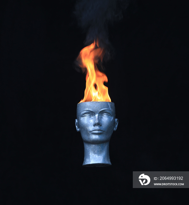 Fire on head.Mannequin head burns on a black background