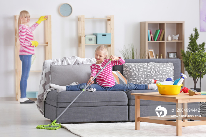 Little girl and her mother cleaning up at home