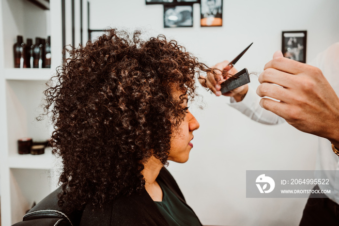 Beautiful latin woman with short curly brown hair getting a treat at the hairdresser. Latin hairdres