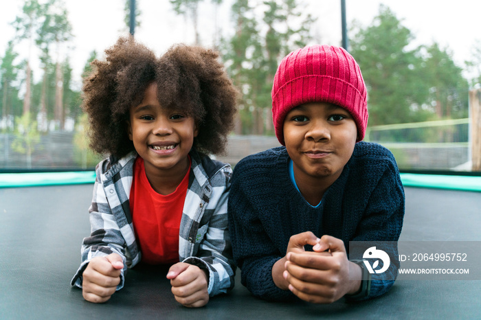 Black two boys smiling while playing in bounce house