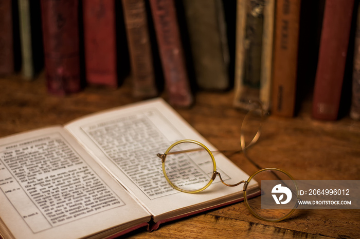 old books on the wooden bookshelfs, vintage eyeglasses