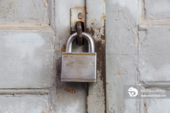 Old lock on wooden grungy painted door closeup.