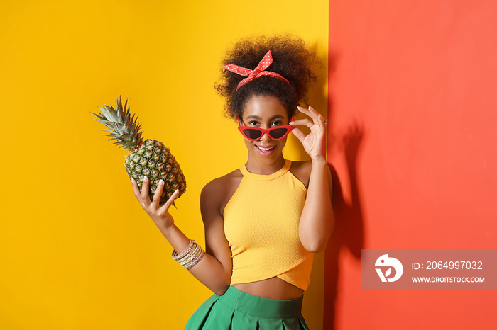 美丽的非裔美国女人，在彩色墙附近有菠萝