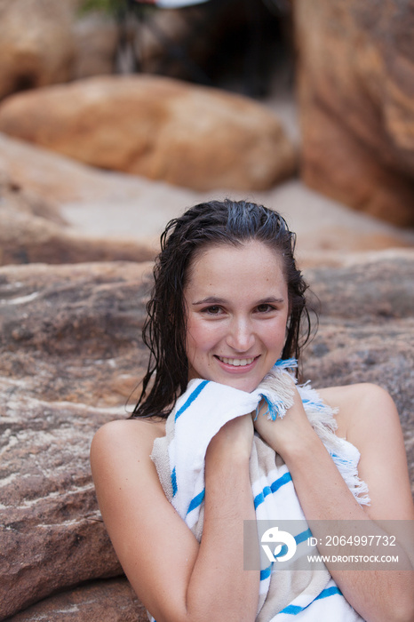 Portrait smiling young woman with wet hair drying off with towel