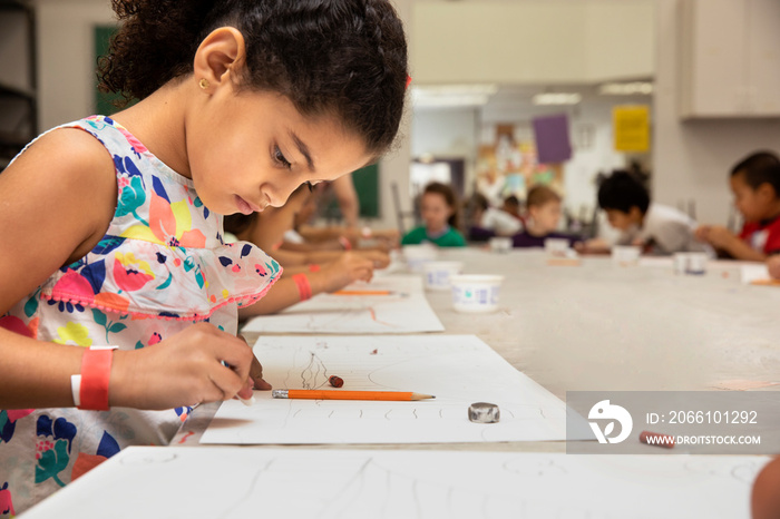 Young girl drawing in a classroom