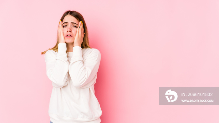 Young caucasian woman isolated on pink background whining and crying disconsolately.