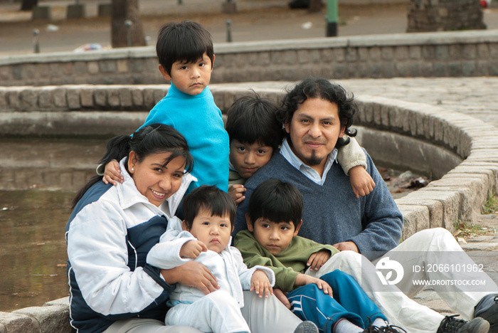 Happy Latin family sitting in the street