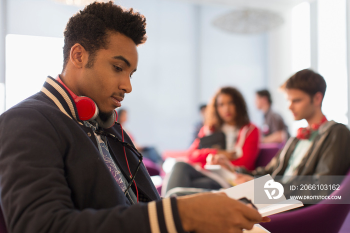 Young male college student studying in student lounge