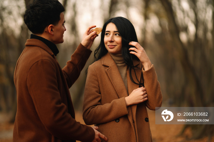 Stylish young couple outdoors on a beautiful autumn day in the forest. Young couple in love holding 