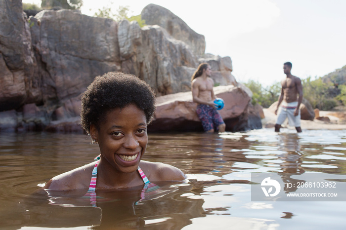 Portrait happy young woman swimming in lake