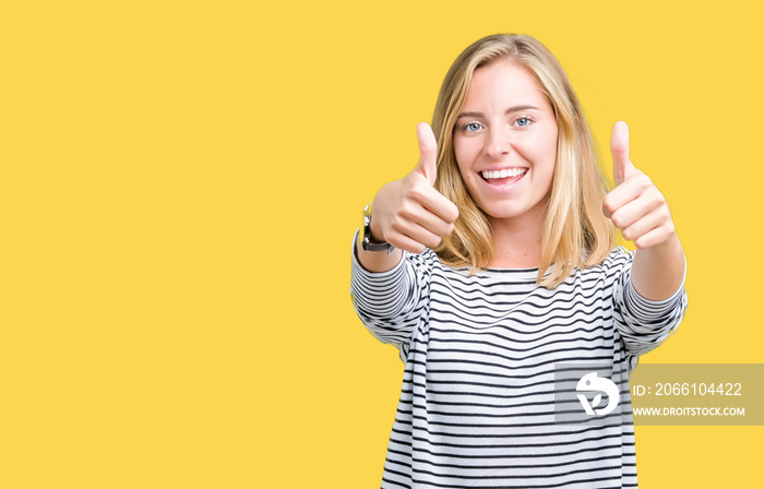 Beautiful young woman wearing stripes sweater over isolated background approving doing positive gest