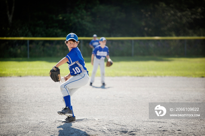 Baseball player throwing ball in field