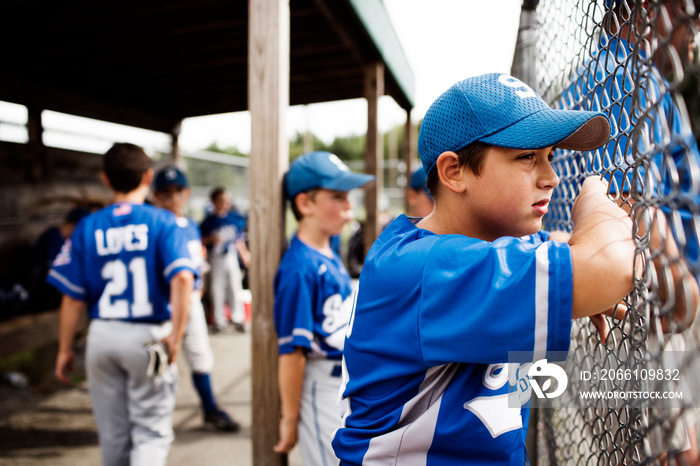 Baseball players looking through fence