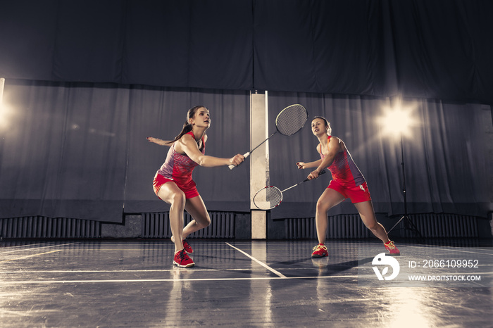 Young women playing badminton at gym