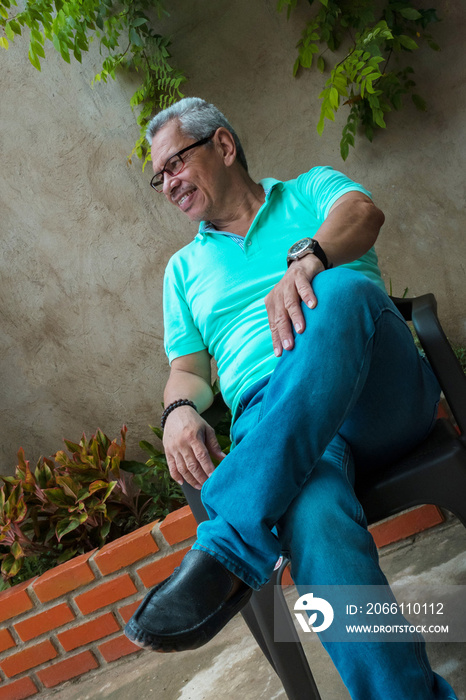 Relaxed adult male in the backyard of a house.