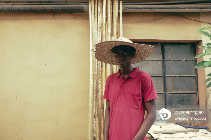 Portrait of boy with a straw hat at their family backyard