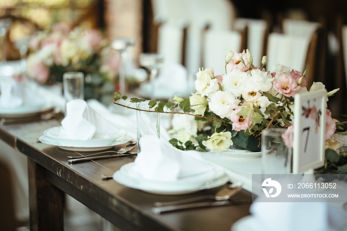 Floral centerpiece on dining table at wedding venue.