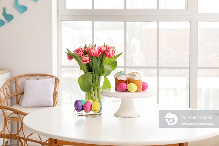站在厨房餐桌上放复活节蛋糕、鸡蛋和郁金香