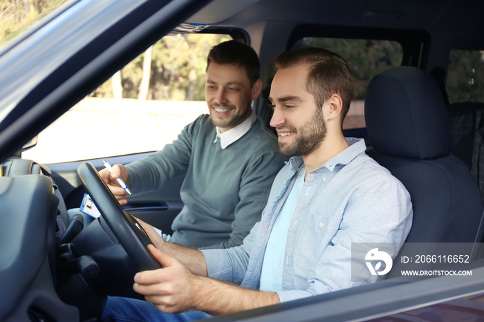 Young man and driving instructor in car